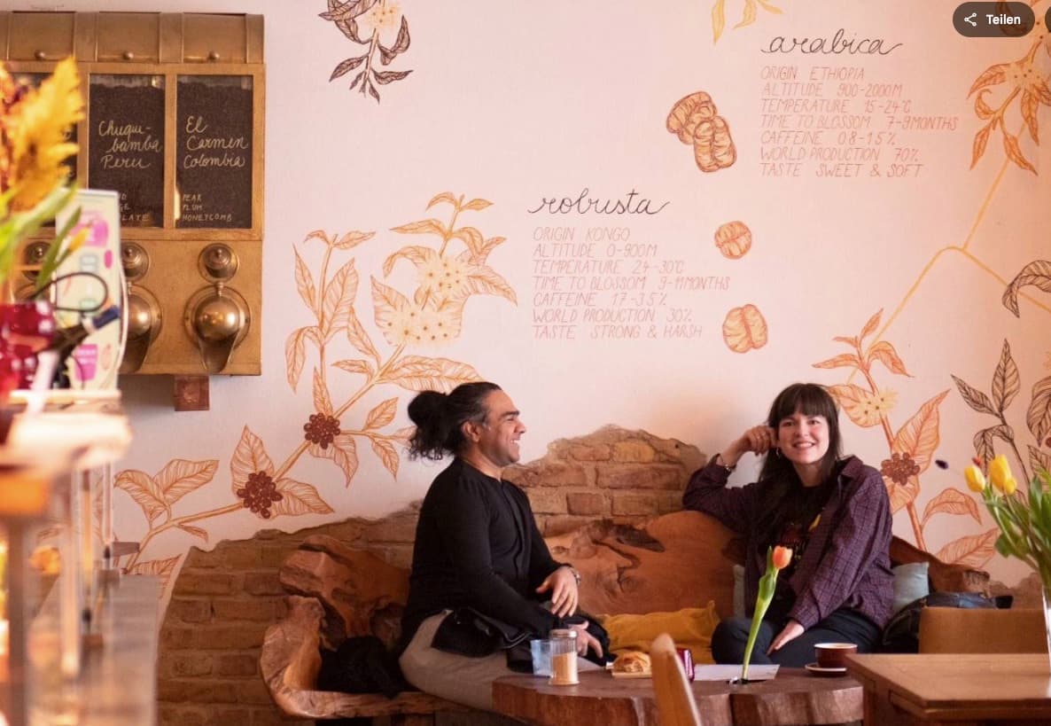 Gemütliche Sitzecke mit Kaffeepflanzen-Wandmalerei